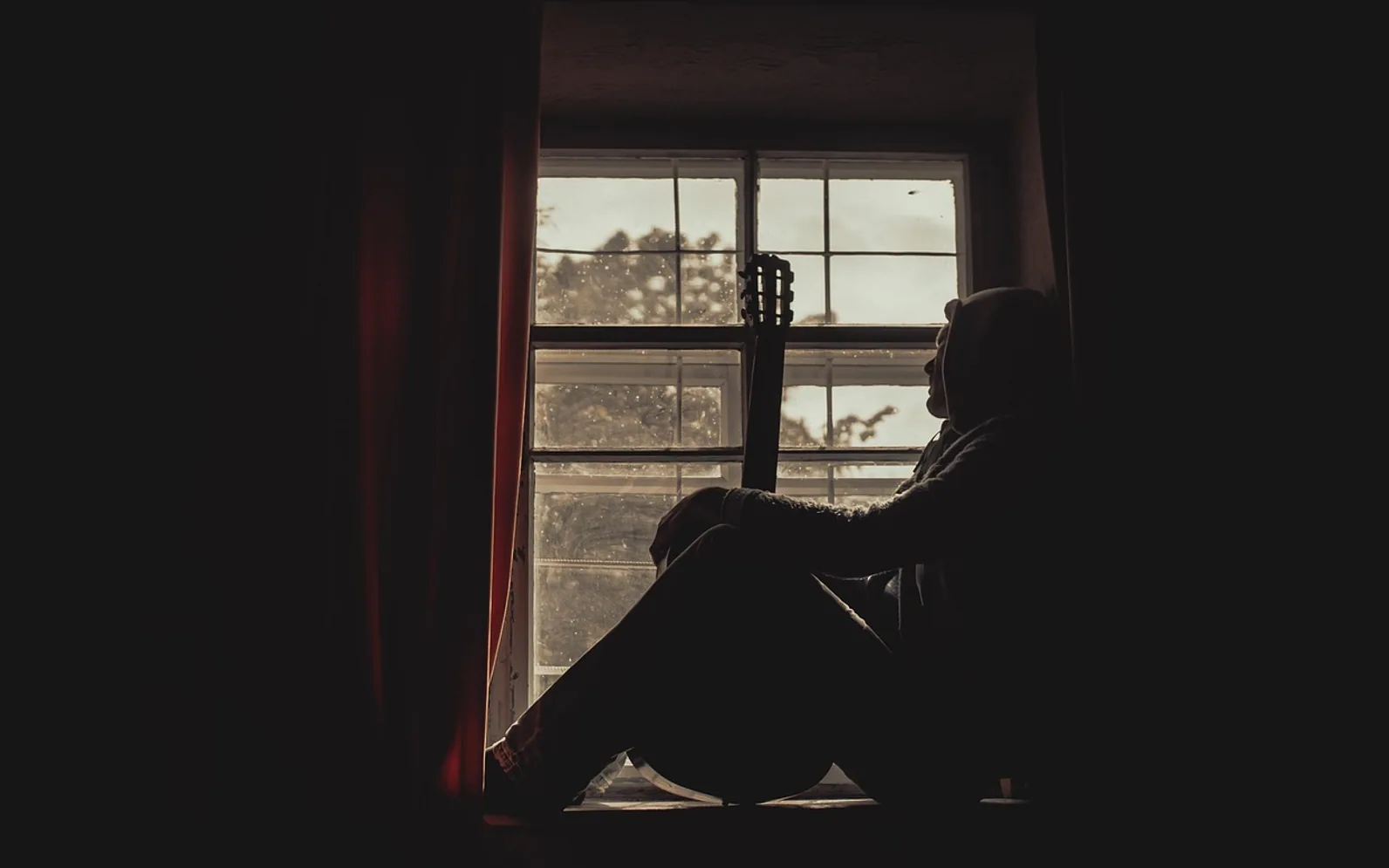 Man, window and guitar